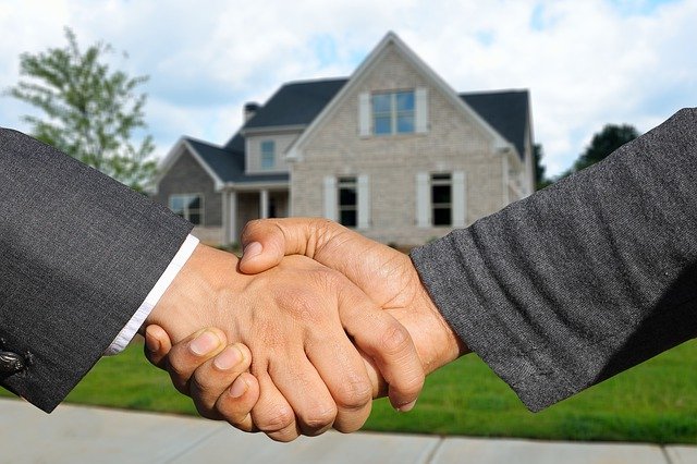 Letting Agent shaking hands near a property