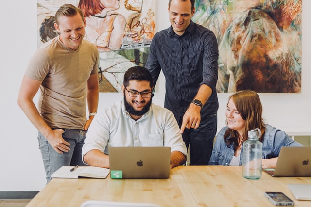 Team members of an office looking at a laptop